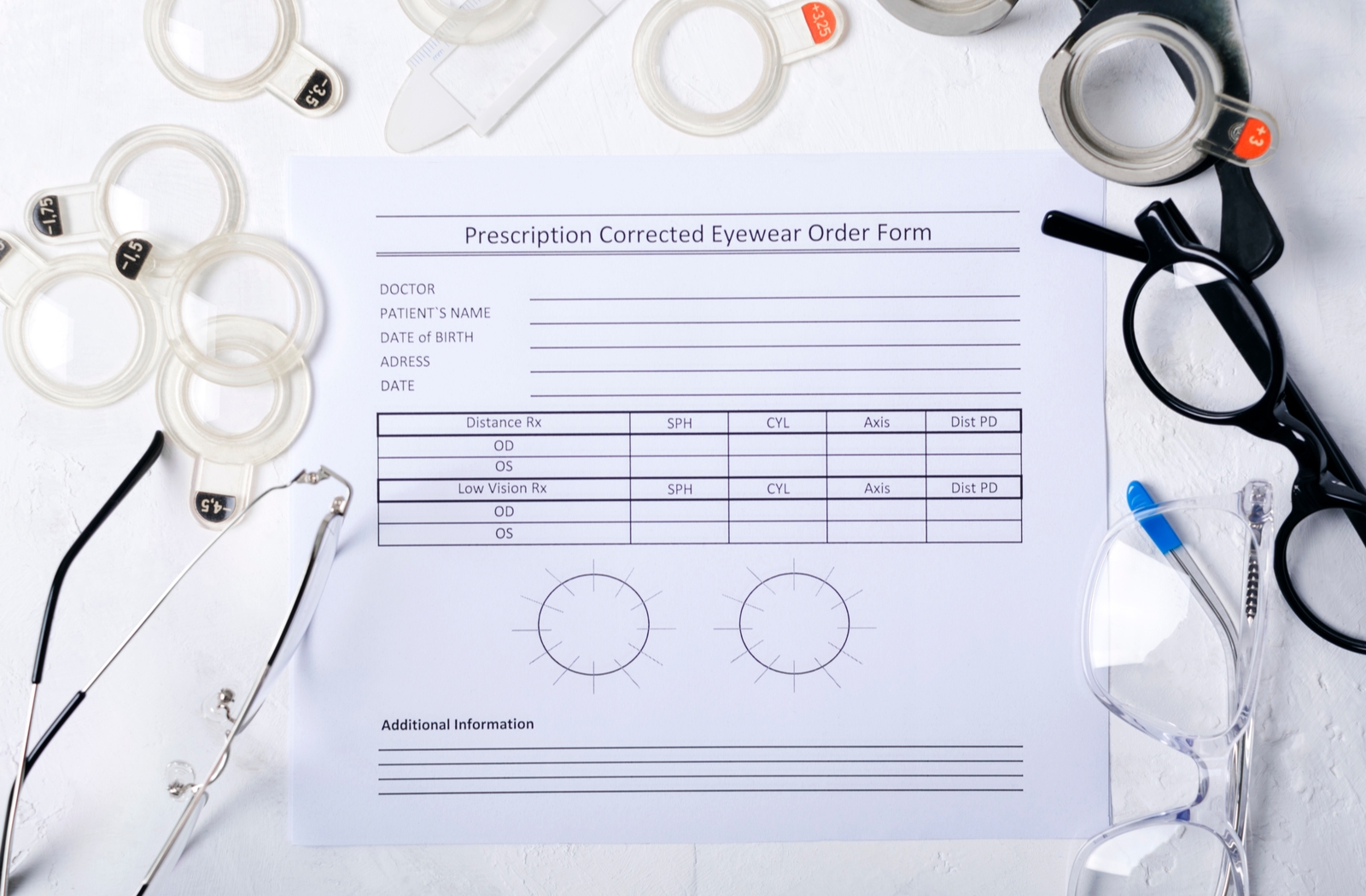Topdown view of a prescription corrected eyewear order form surrounded by glasses and various optical tools.