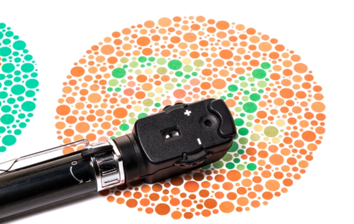 An Ophthalmoscope resting on a chart used to test colour vision