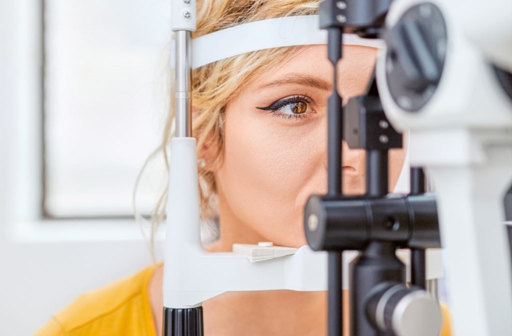 A woman at her optometrist undergoing a slit lamp test to check her vision at her regular eye exam