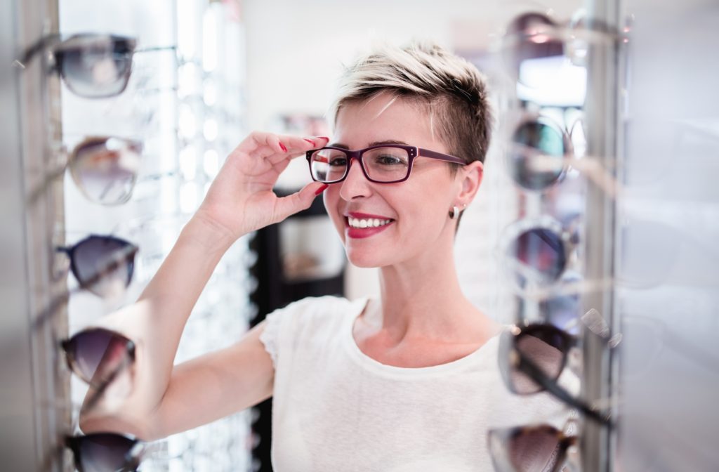 A woman at her optometrist picking out new glasses with a wide range of selection