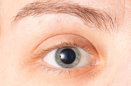 A close up of a woman's dilated pupil after an eye exam