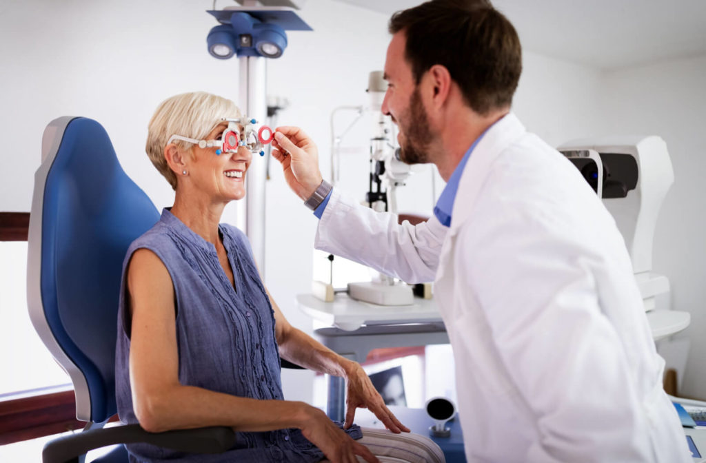 An elderly woman taking an eyesight test examination at an optician clinic to get a new prescription for her expired prescribed lenses.