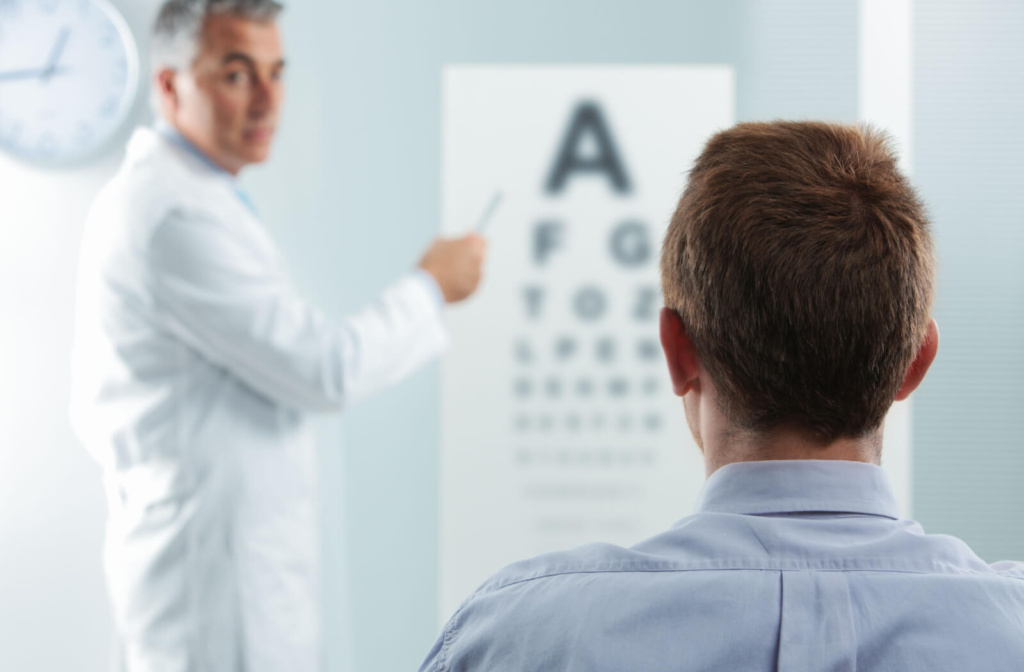 An optometrist conducting a visual acuity test with his patient.