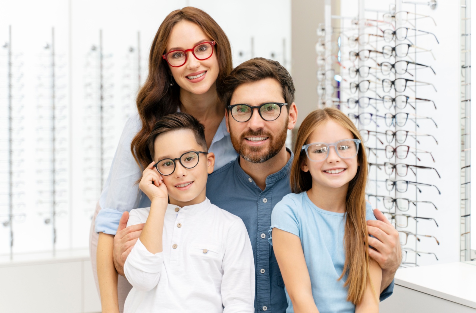 A family poses together for the camera, each of them wearing a pair of glasses.