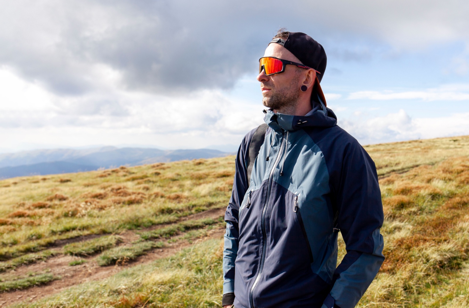 An adult wearing sunglasses to protect their eyes while on a hike.