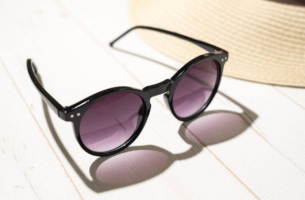 An image of black sunglasses with purple-tinted lenses.