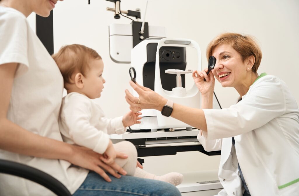 An eye doctor assessing a baby's eye tracking and focusing during a routine eye exam.