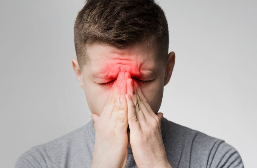 A man covers his nose as a red glow indicates where his swollen sinuses are.